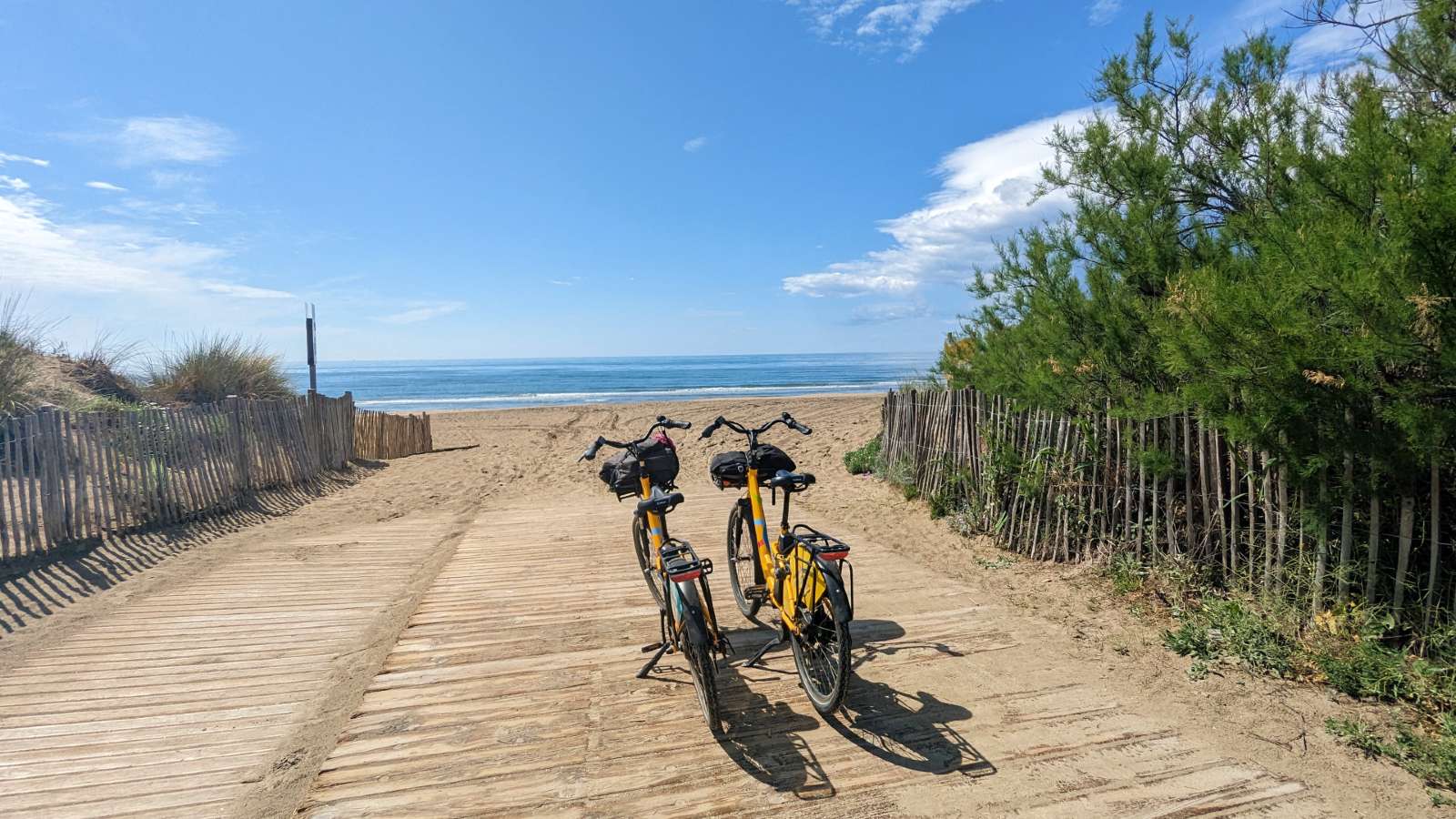 2 vélos sur le bord de la plage de la Baleine à Sète avec vue sur la Méditerranée entre les dunes